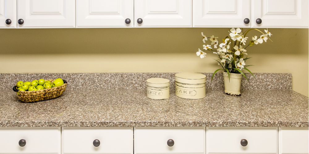 A modern ktichen with white wood cabinets and new granite countertop