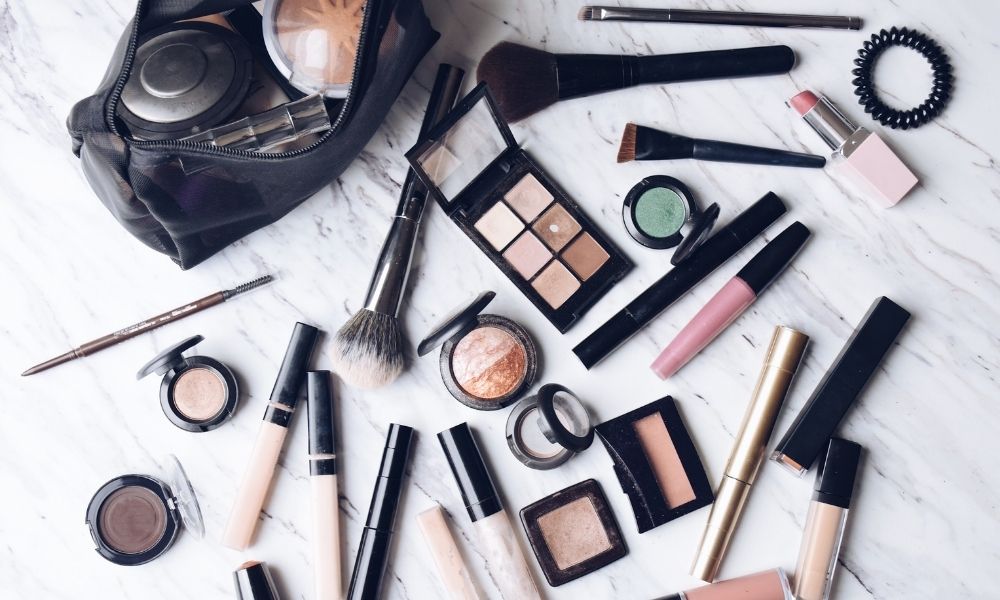 Makeup and cosmetic bag on a marble countertop surface