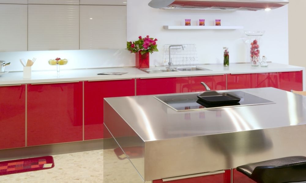 Stainless steel countertop island with red kitchen cabinets