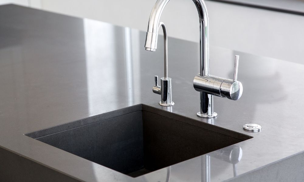 Modern polished stainless steel countertop with granite kitchen sink