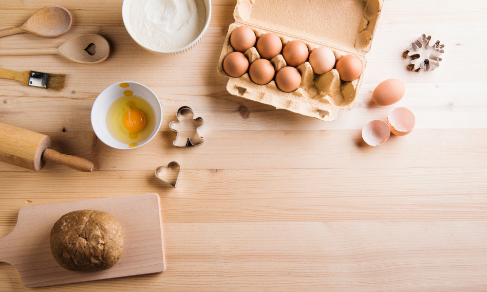 Baking ingredients and kitchen utensils on reclaimed wood countertop