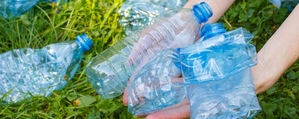 Picking up discarded mineral water plastic bottles for recycling