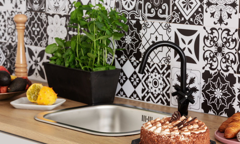 Cake, Herbs and fruits on kitchen counter in bright kitchen interior with trendy tiles on the wall