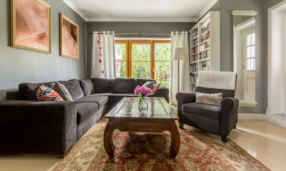 Comfortable living room interior with gray corner sofa and classic coffee table