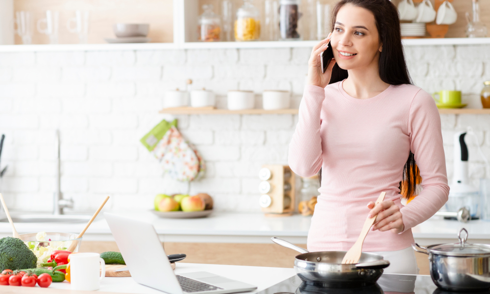 Woman cooking a meal while working from home