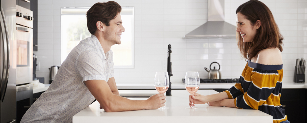 Couple drinking wine at white quartz kitchen island