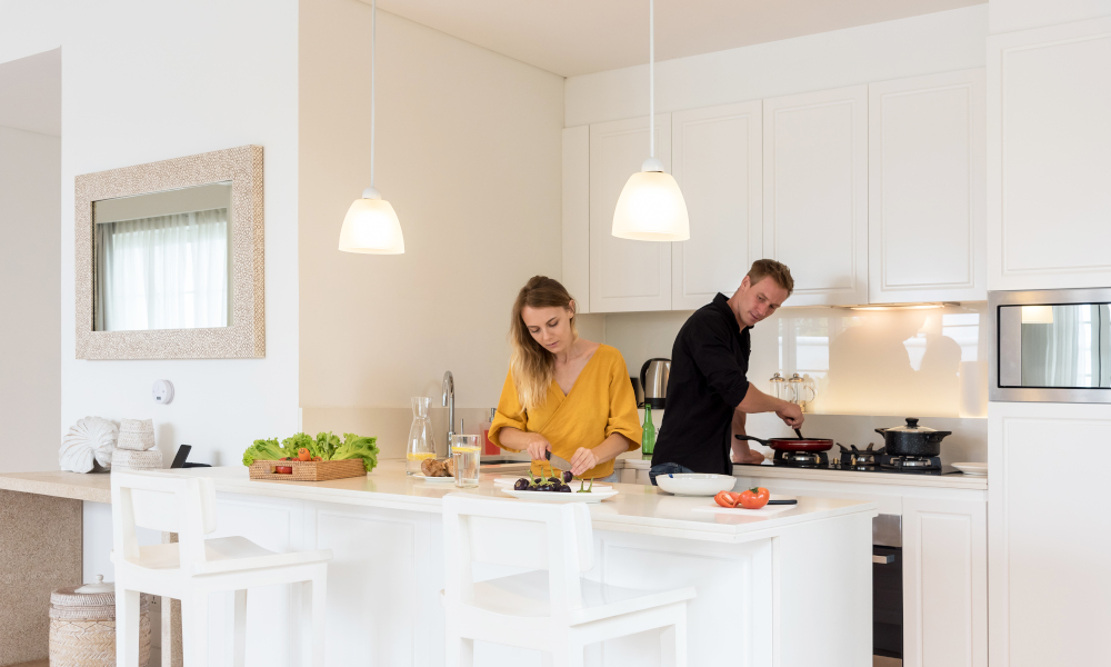 Couple making lunch on a white island kitchen at home