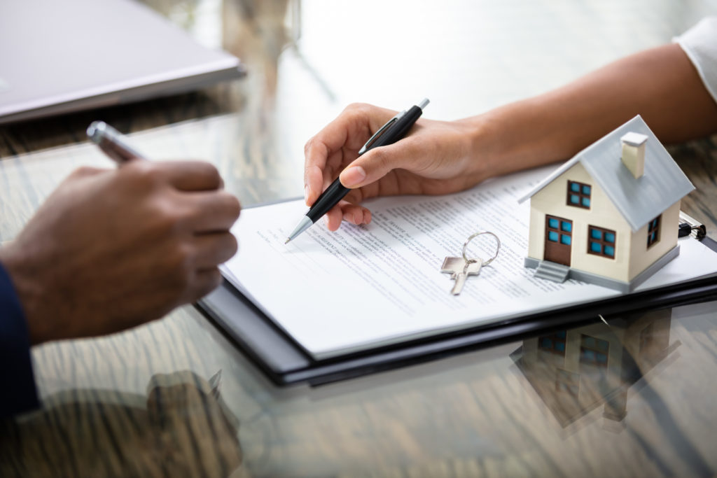 Businessman Signing Real Estate Contract Lease With Keys On It