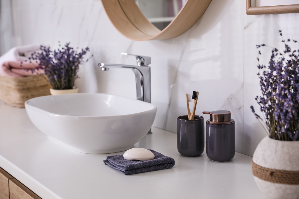 Best bathroom countertop material. Bathroom counter with vessel sink, accessories and flowers. Interior design