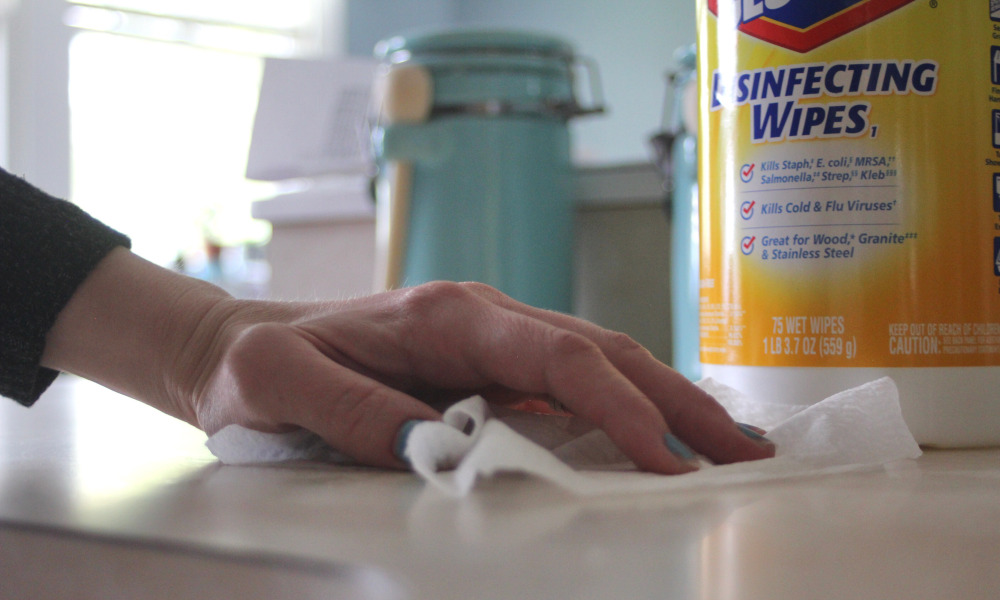 Wiping the countertop with disinfecting wipes