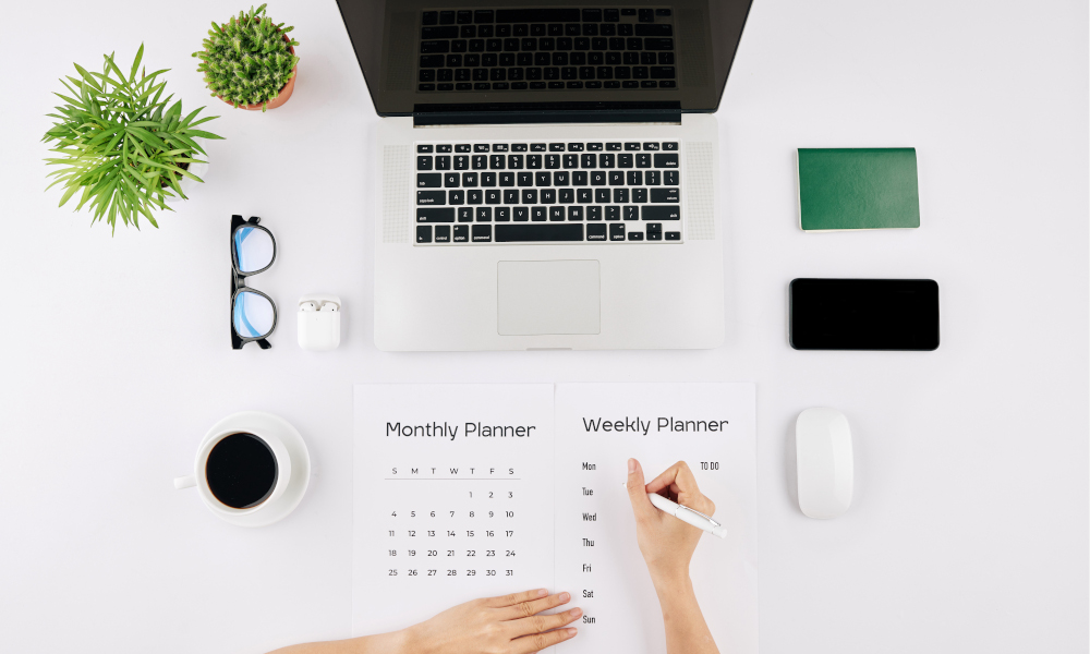 Hands of young female entrepreneur checking calendar and filling weekly planner