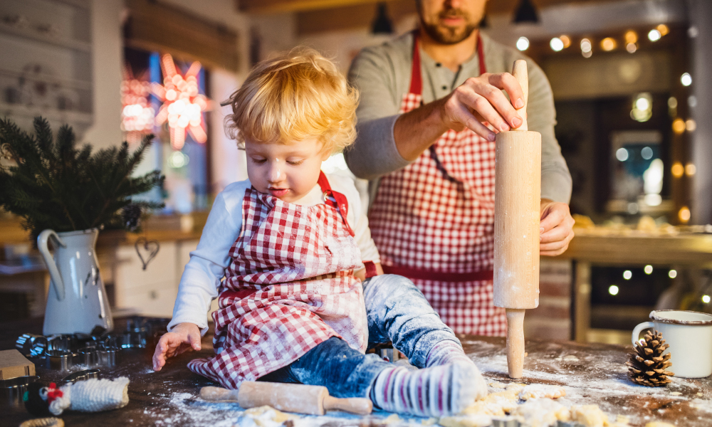 Man and toddler boy making cookies at home. Father and son baking gingerbread Christmas cookies.