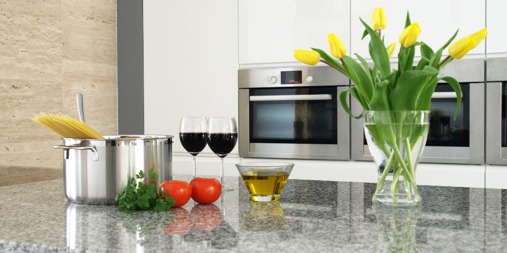 Pasta, tomatoes, olive oil and wine on a shiny granite countertop