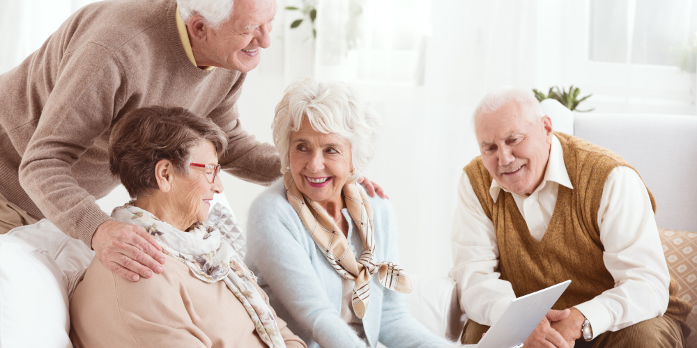 Happy pensioners of senior house using computer