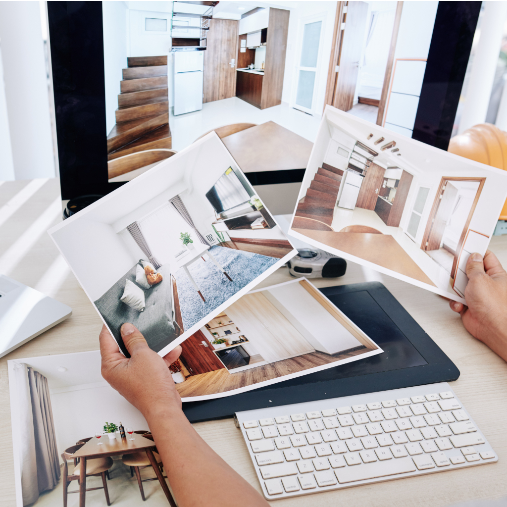 Interior designer sitting at desk and looking at printed photos of clients rooms after renovation