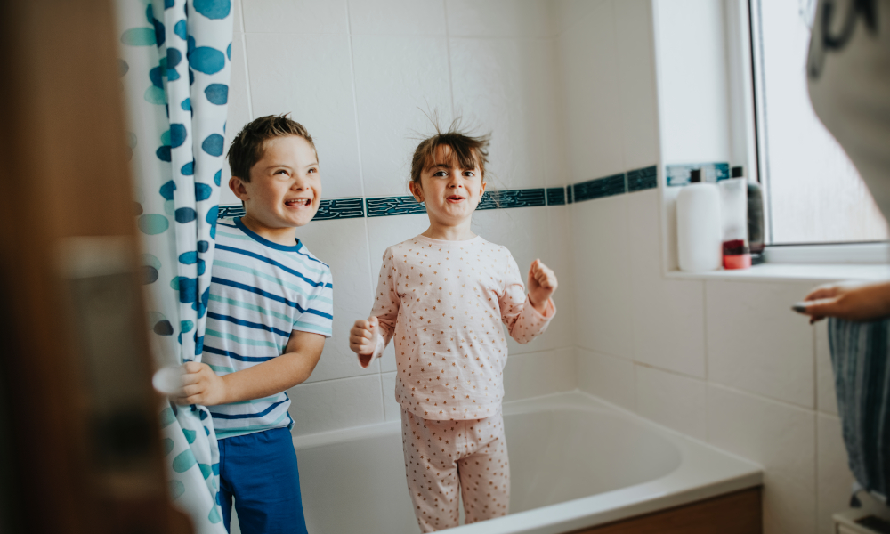 Brother and sister playing hide and seek behind shower curtain in the bathroom