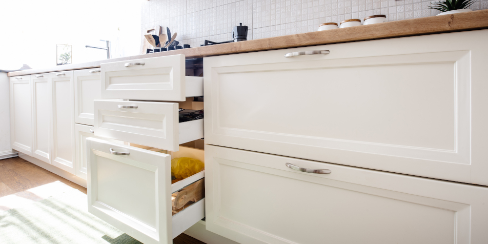 Modern kitchen cabinets and open drawers in white