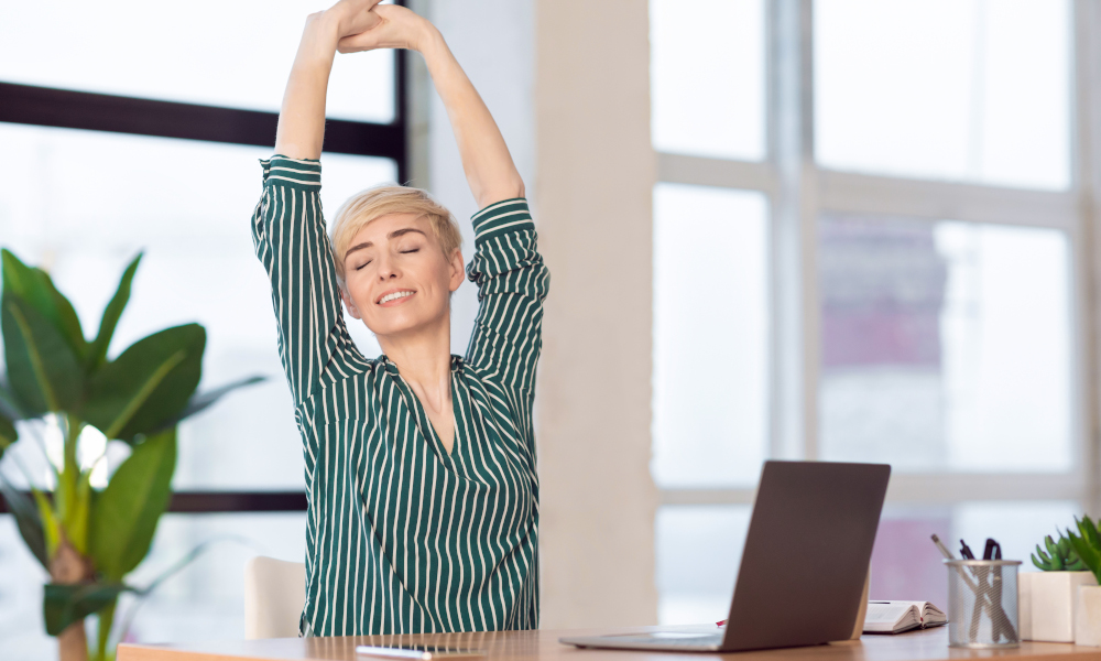 Break At Work. Entrepreneur Lady Stretching Hands With Eyes Closed Working At Laptop Sitting In Modern Office.