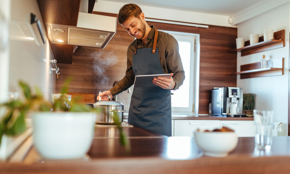 Smiling young man cooking in the kitchen at home