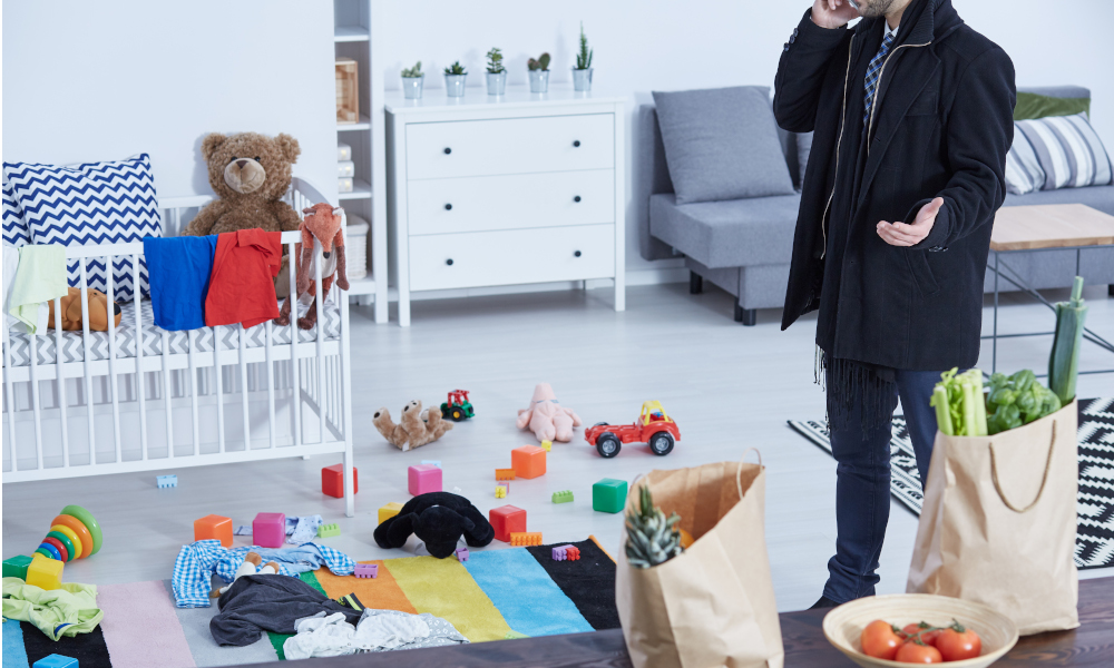 Messy playroom with a busy father on the phone