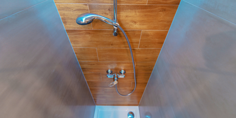 Shower fixture in elegant bathroom with wooden inspired tiles