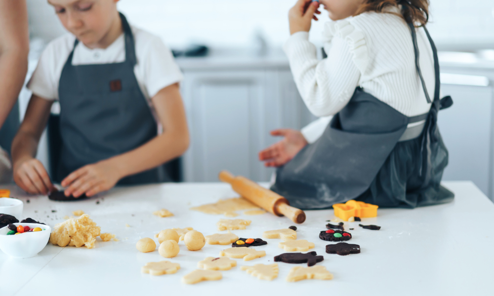 Mother and her two kids baking butter and chocolate cookies in the kitchen