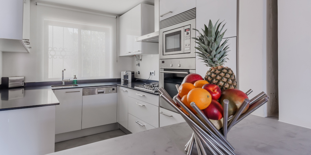 Newly renovated kitchen in a modern apartment with white walls and light grey floor