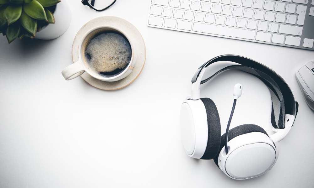 Home office desk workspace with Headphones, glasses, coffee and keyboard on white background