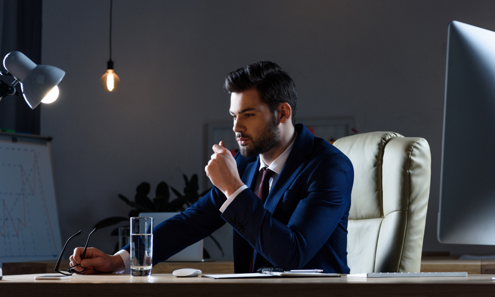 Pensive businessman sitting at working table in evening