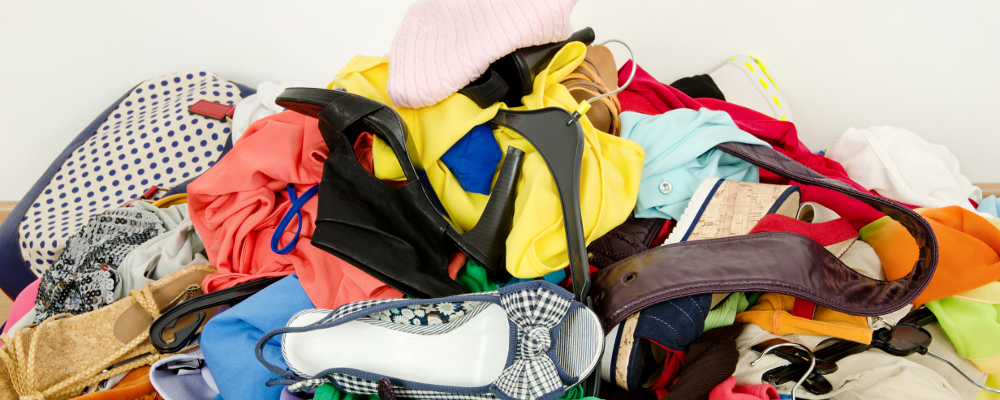 messy pile of clothes and shoes on bed