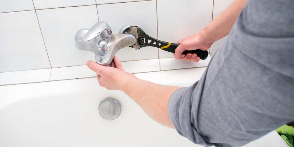 Plumber installing faucet during bathroom renovation