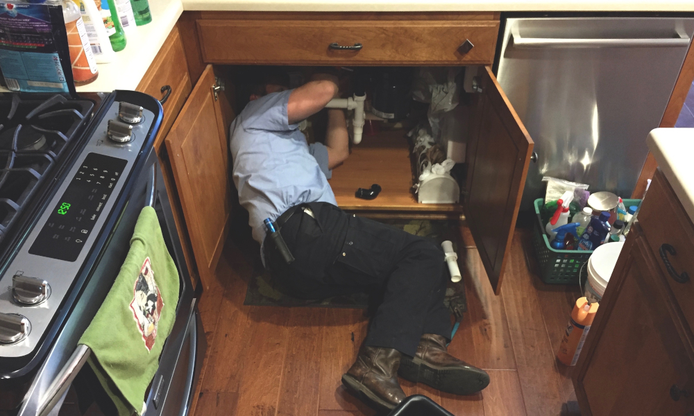 Plumber fixing a leaking sink