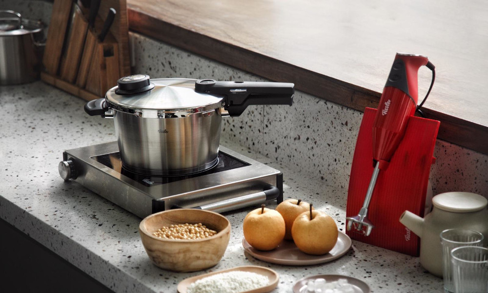 Portable kitchen stove with pot and cooking ingredients on a terrazzo kitchen countertop