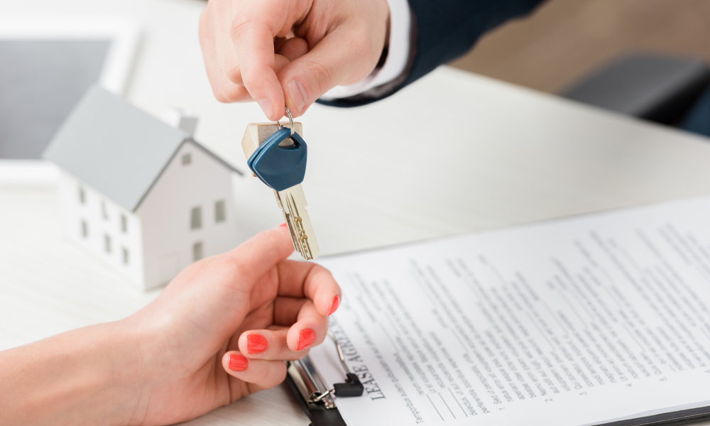 Realtor giving key to new homeowner after signing the lease