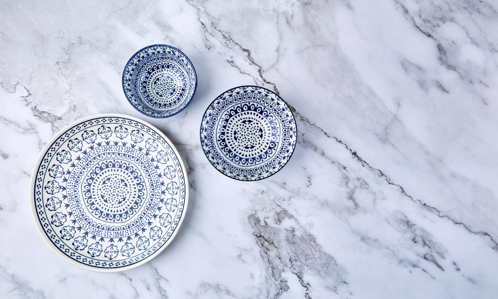 Set of modern trendy blue plates on marble countertop