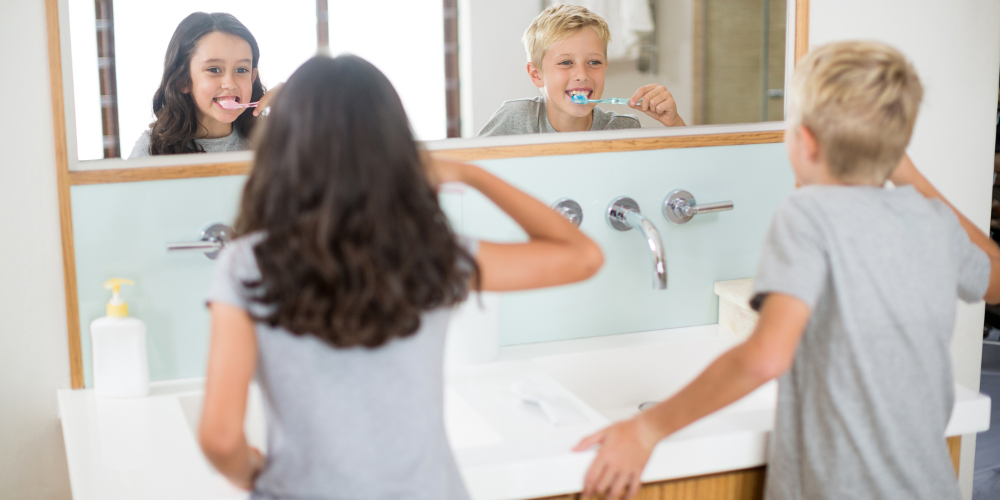 Happy children brushing teeth at bathroom stone sink