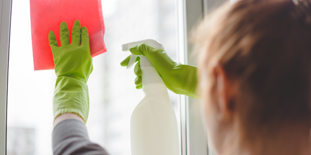 Women cleaning a window with spray and cloth