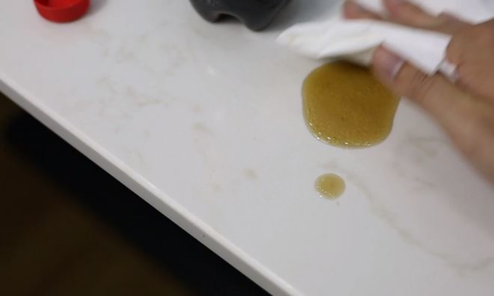 Wiping coffee spills on quartz office desk surface