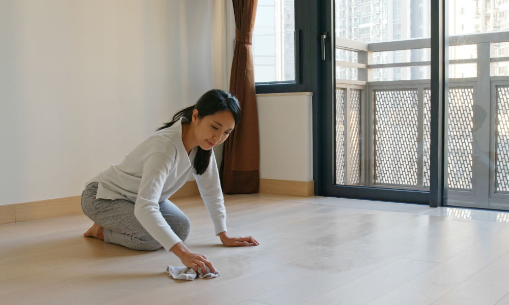 Woman cleaning the floor after dusting the ceiling and fan