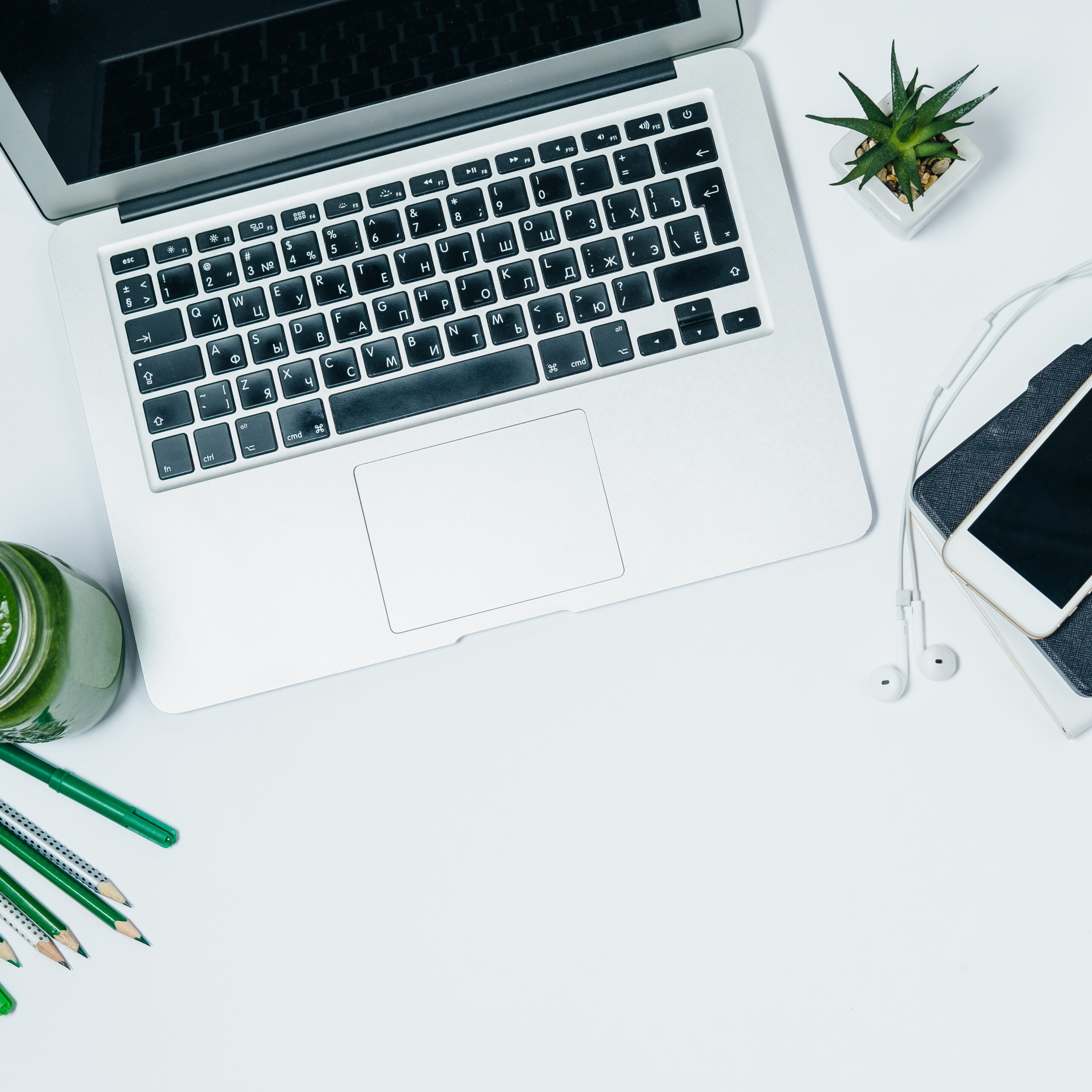 Healthy desktop with green smoothie and laptop on white background. Top View Space for Text