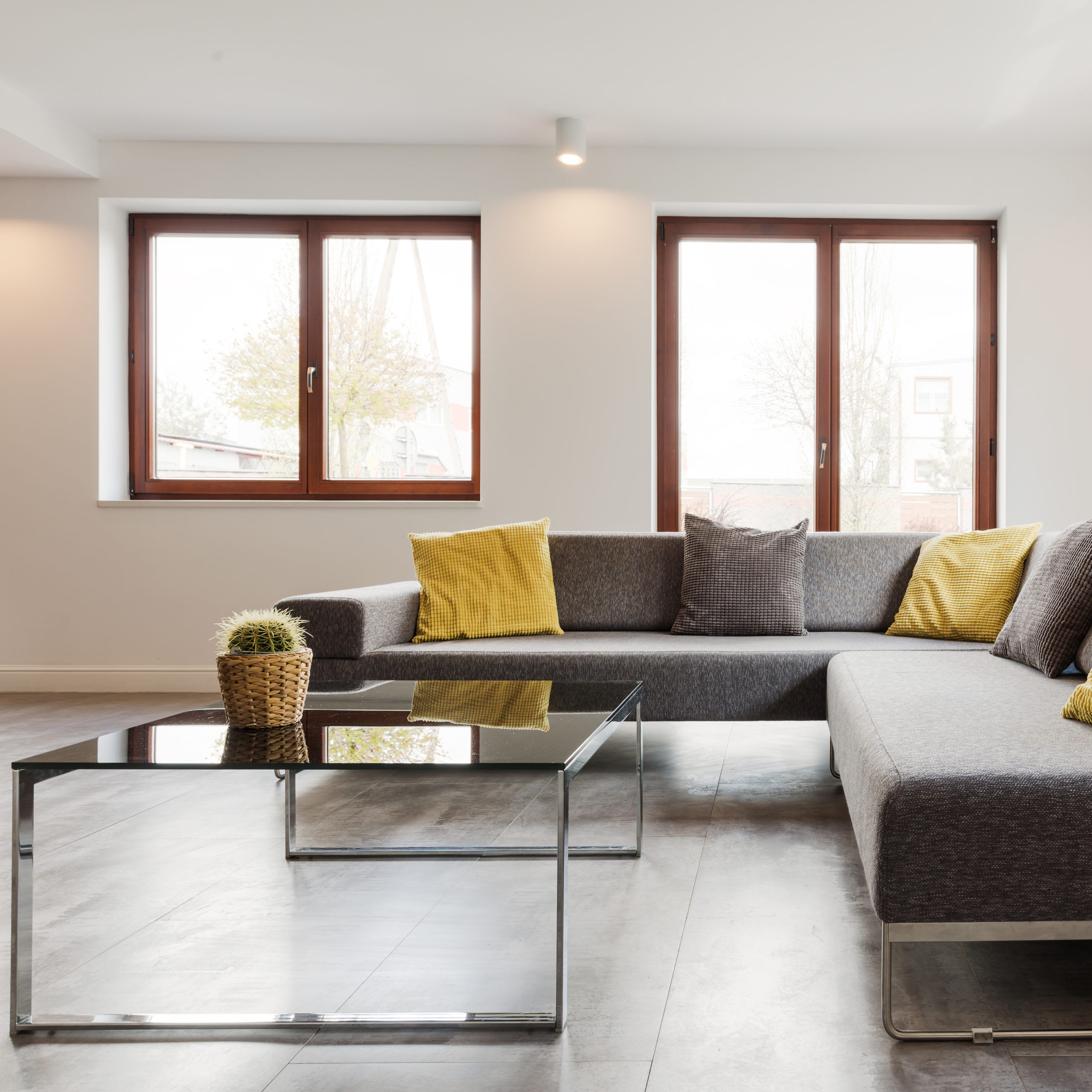 Large corner sofa and glass coffee table in a very modern and light house interior